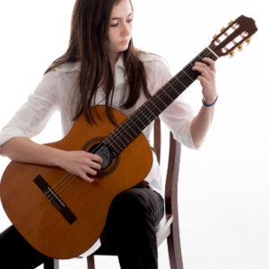 Girl sitting in chair during guitar lesson